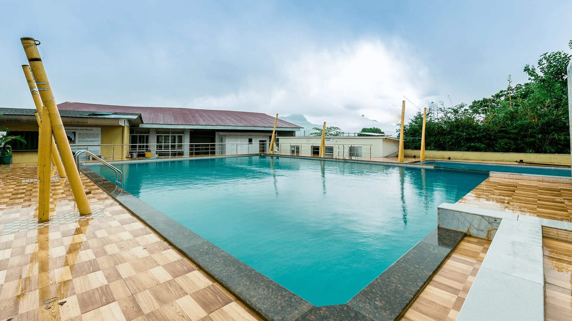 Relaxing poolside area at Rainforest Igatpuri, ideal for leisure and enjoying the scenic surroundings.